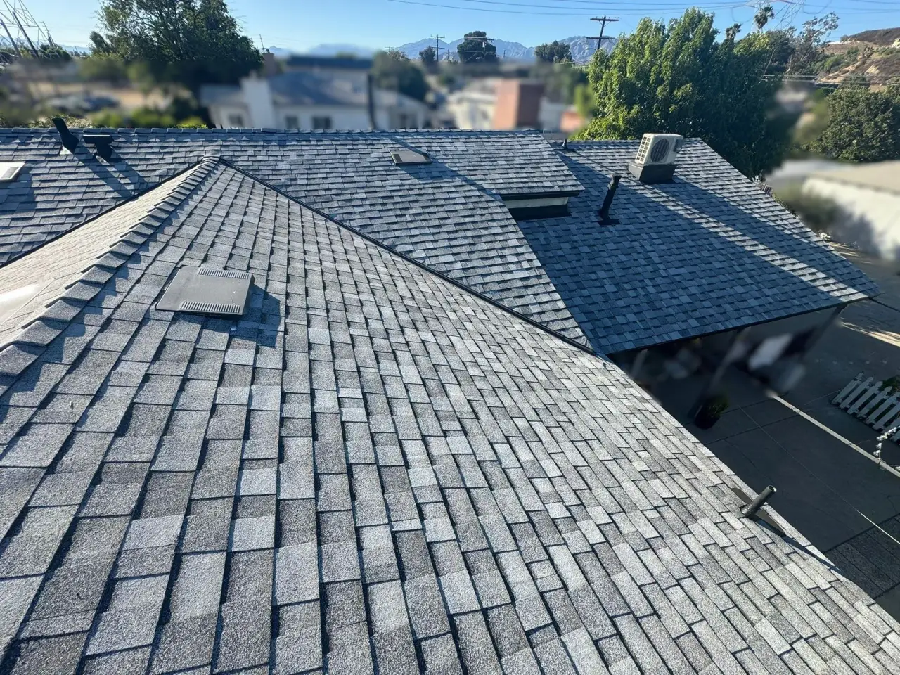 Close-up of new architectural shingles with mountain backdrop